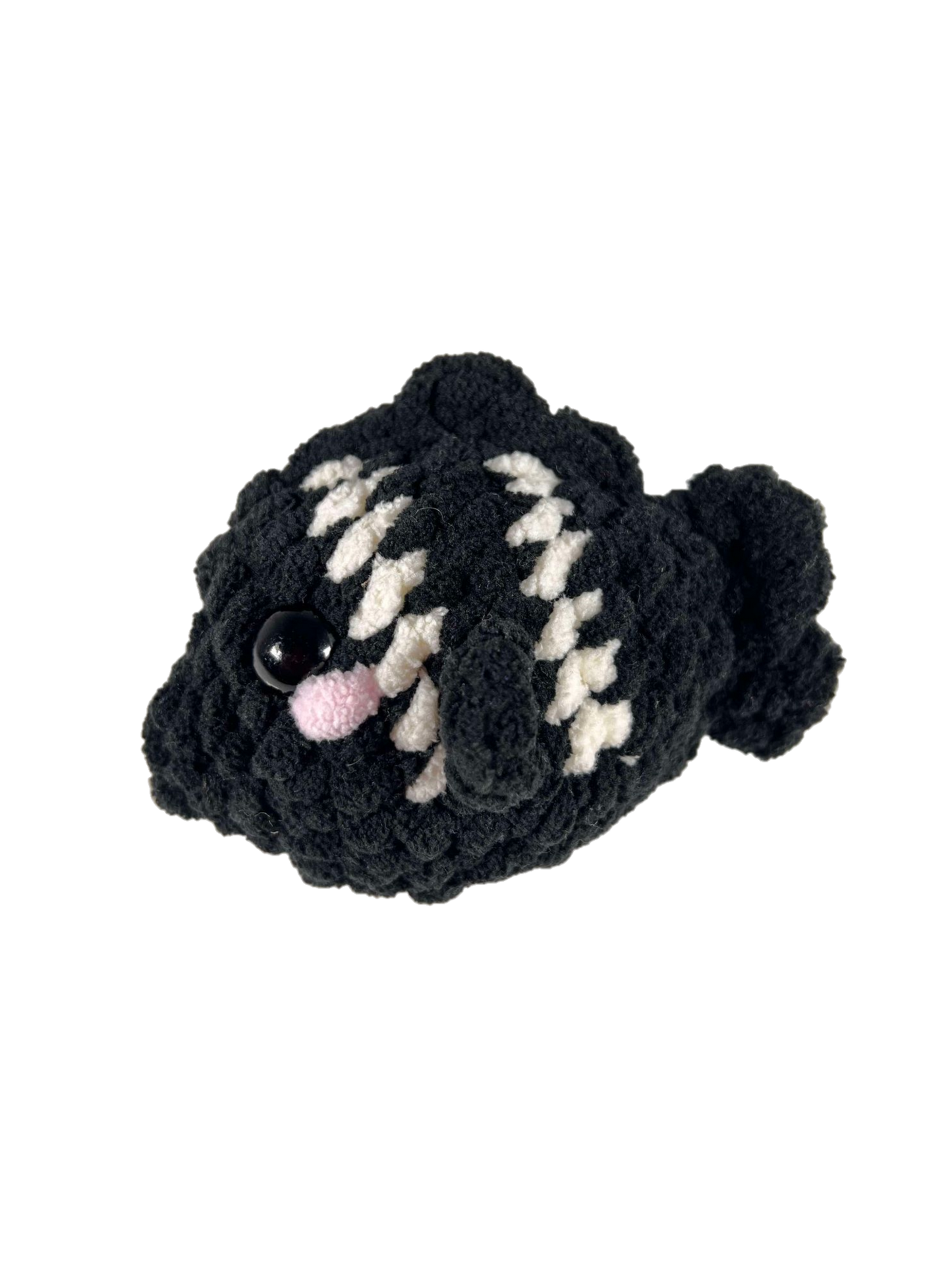 Black crochet fish plushie with 2 white stripes facing left.