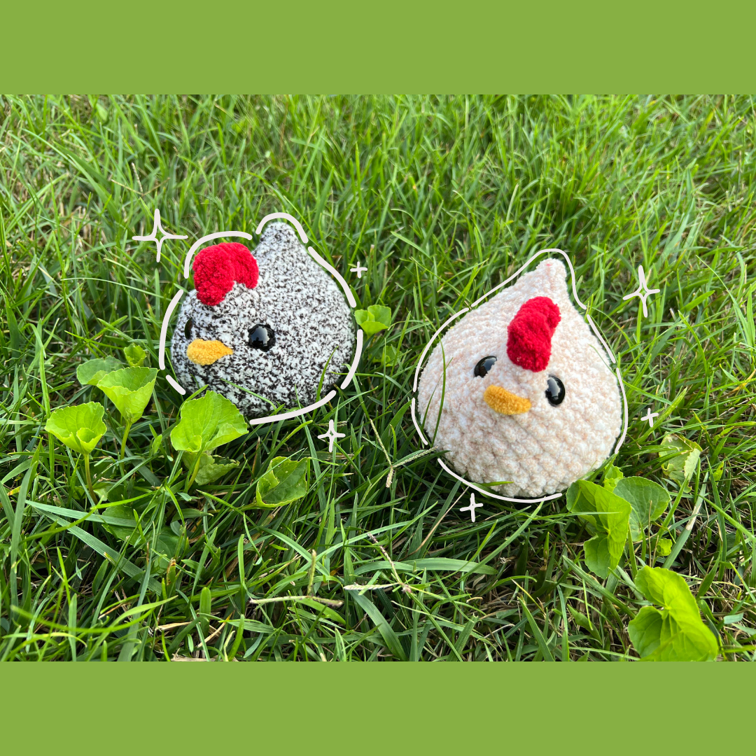 Two crochet chickens sitting on grass with a white outline.