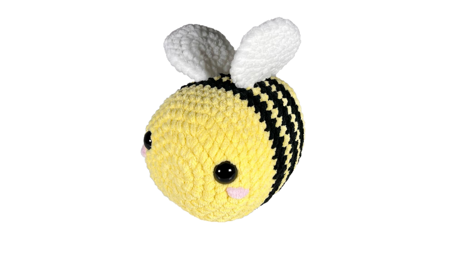 Huge yellow crochet bee with three black stripes and pink rosey cheeks.