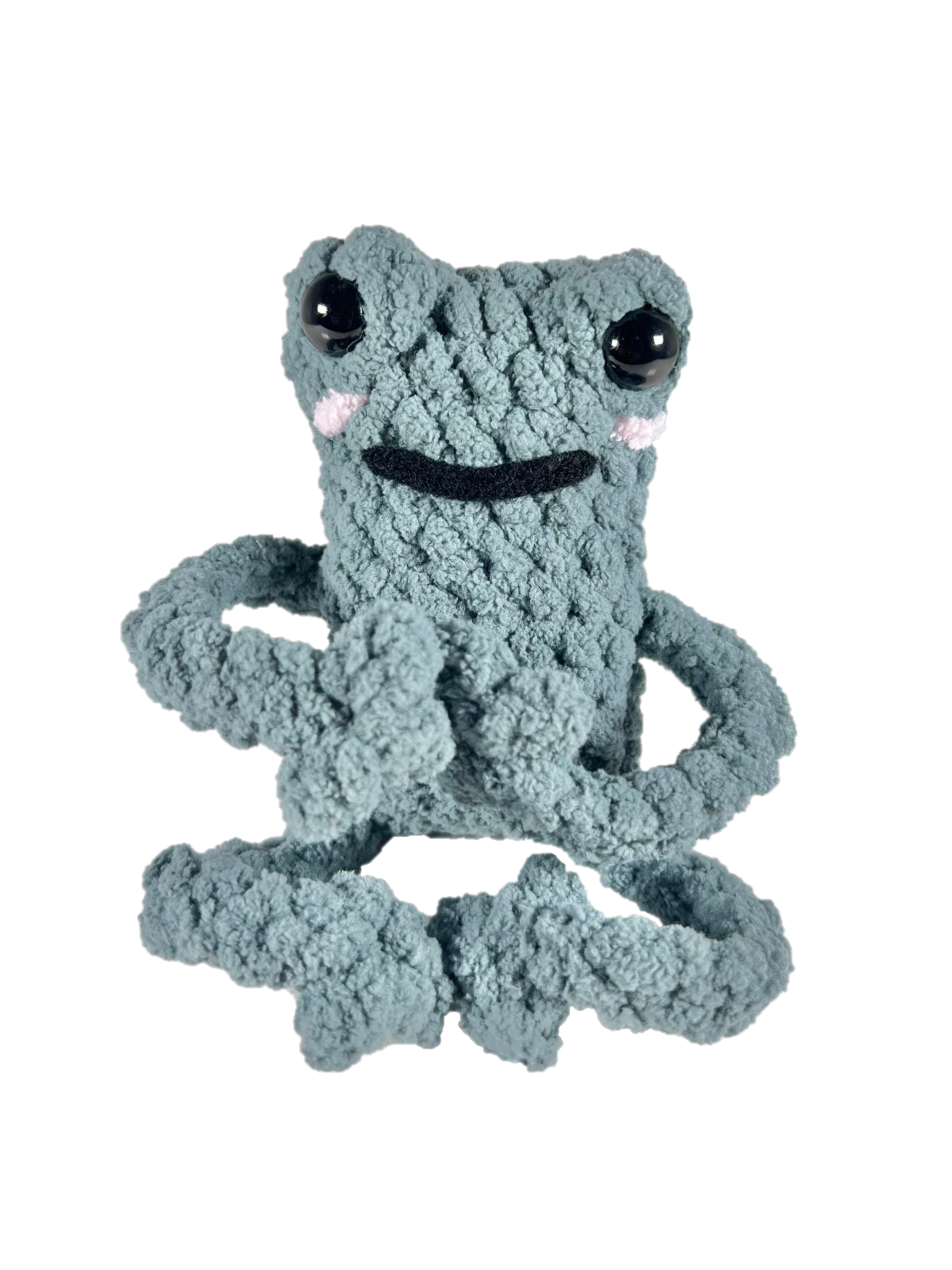 Green crochet frog in yoga pose.