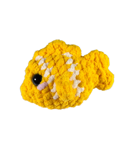 Yellow crochet fish plushie with 2 white stripes facing left.