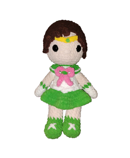 Plush toy figure of a character with brown hair, green outfit, and pink bow on a white background