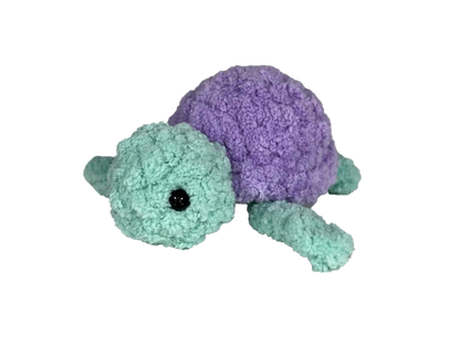 Green crochet turtle with a purple shell.