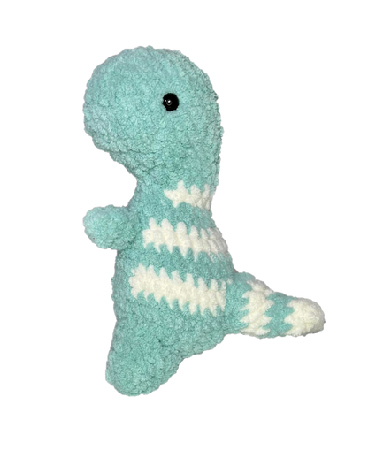 Green crochet dinosaur looking left.