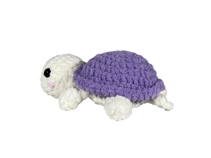 White turtle with purple shell blushing and facing left.